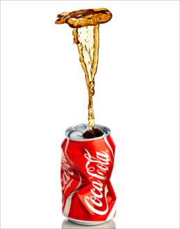crushed coca cola can with coke splash